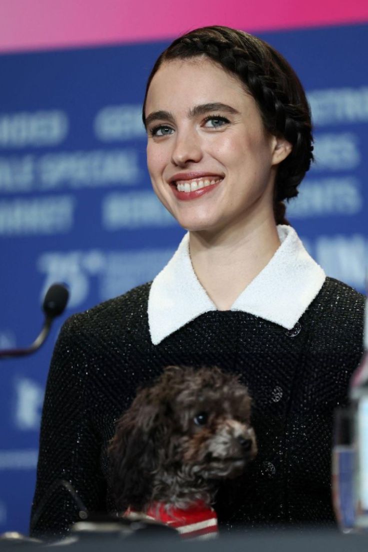 Essa imagem mostra Margaret Qualley sorrindo com um cachorro